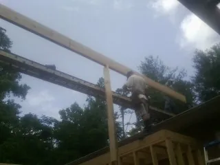 Carpenter setting a ridge beam over a new addition frame — Ice Dam Removal by Roofing Brothers in Briggsdale